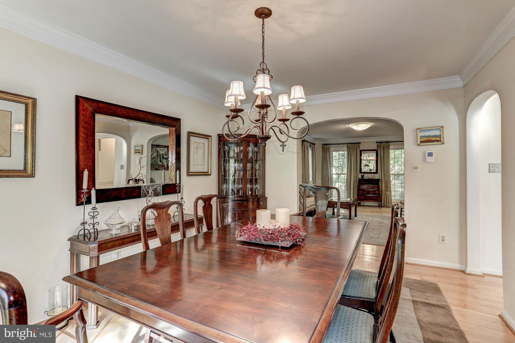2232 Wakerobin Lane Reston, VA 20191 - Photo 10 of 30 a dining room with wooden floor a chandelier a wooden table and chairs