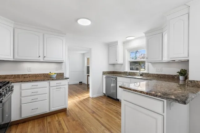 a kitchen with granite countertop wooden cabinets and white appliances