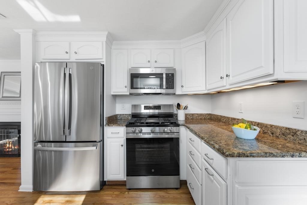 51 Himoor Circle Randolph, MA 02368 - Photo 15 of 29 a kitchen with granite countertop a refrigerator stove and microwave with wooden floor