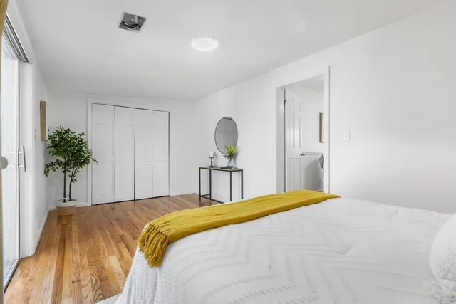 a bedroom with a bed and a potted plant