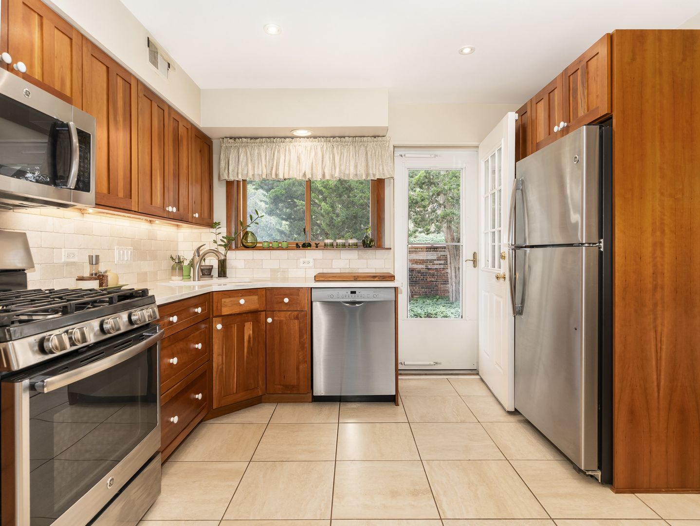 9237 Forestview Road Evanston, IL 60203 - Photo 8 of 33 a kitchen with stainless steel appliances granite countertop a stove a refrigerator and a sink