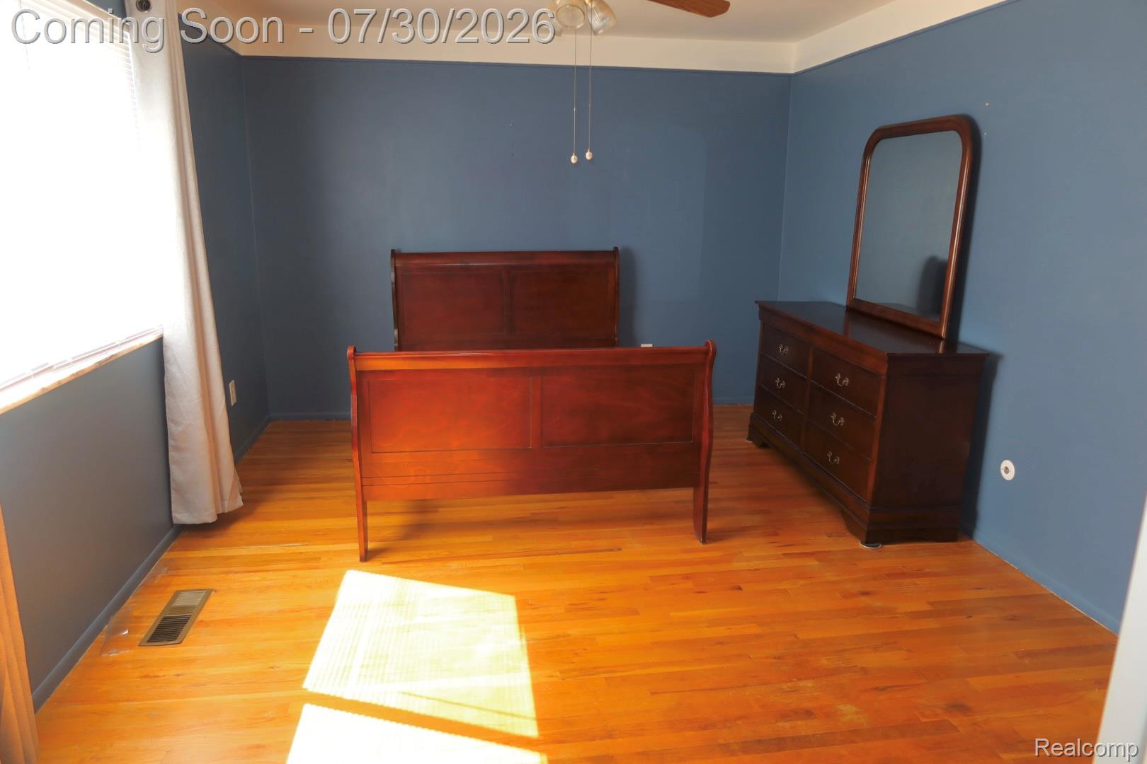 29232 Hoover Road, Unit 232 Warren, MI 48093 - Photo 8 of 22 Hardwood flooring throughout, featuring baseboard trim, crown molding, and a ceiling fan with integrated lighting