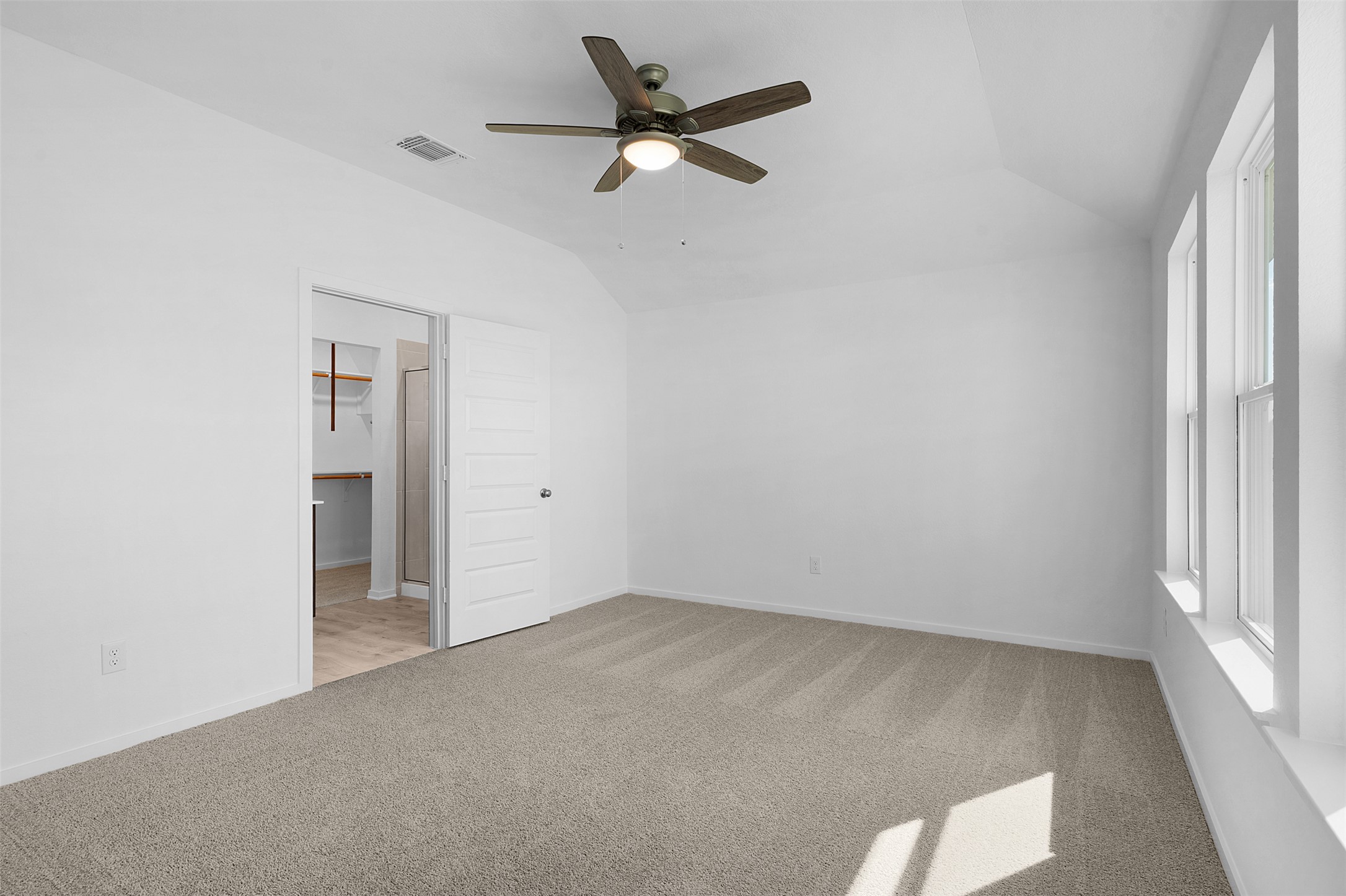 25608 Wheat Seed Lane Elgin, TX 78621 - Photo 8 of 17 Unfurnished bedroom featuring lofted ceiling, light colored carpet, a spacious closet, and a ceiling fan