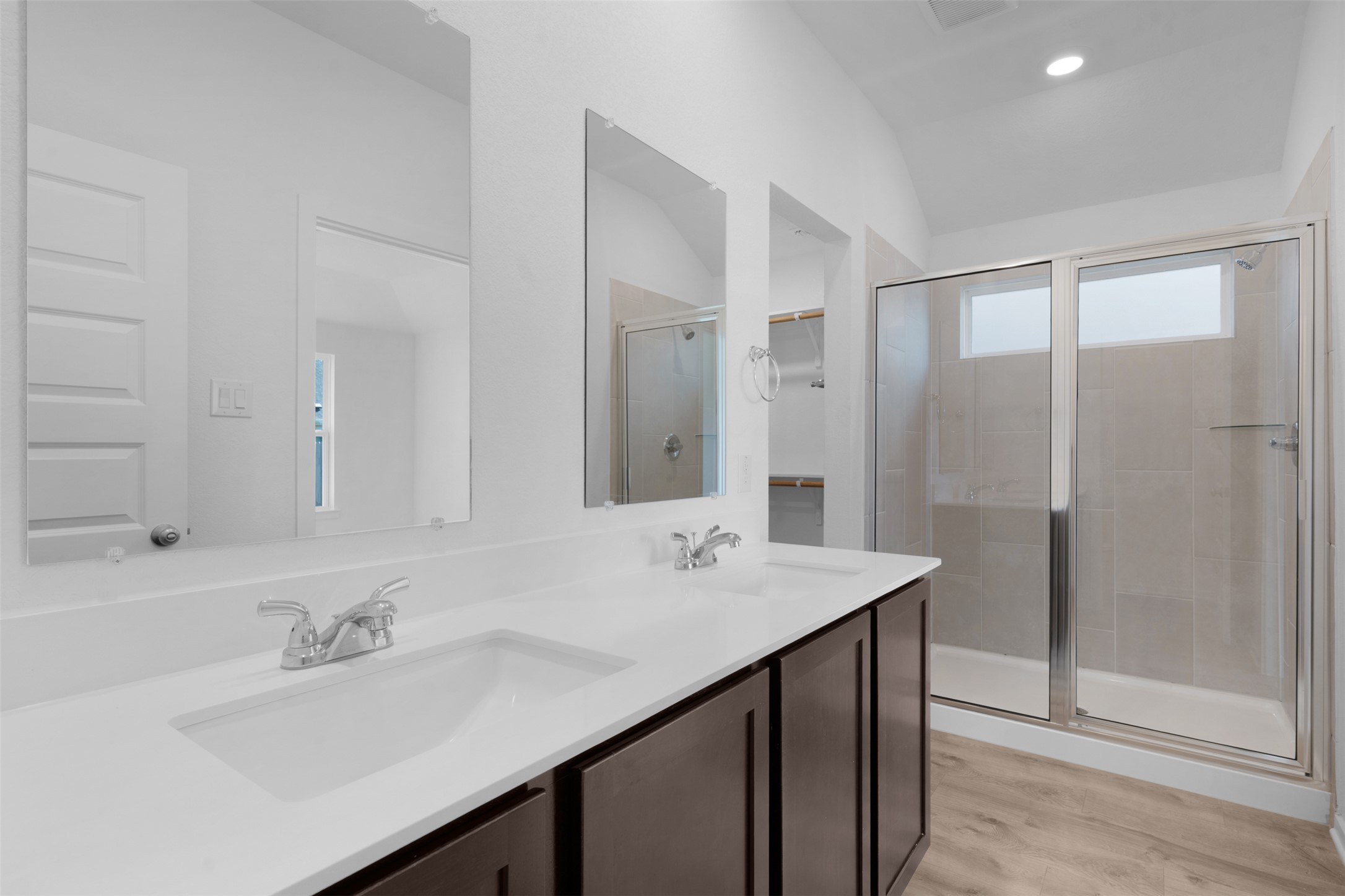 25608 Wheat Seed Lane Elgin, TX 78621 - Photo 9 of 17 Bathroom featuring double vanity, a shower stall, light wood finished floors, a spacious closet, and lofted ceiling