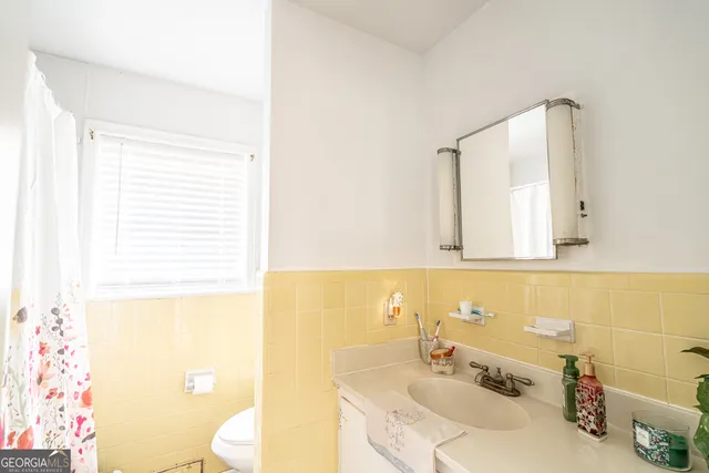 a bathroom with a sink toilet and mirror