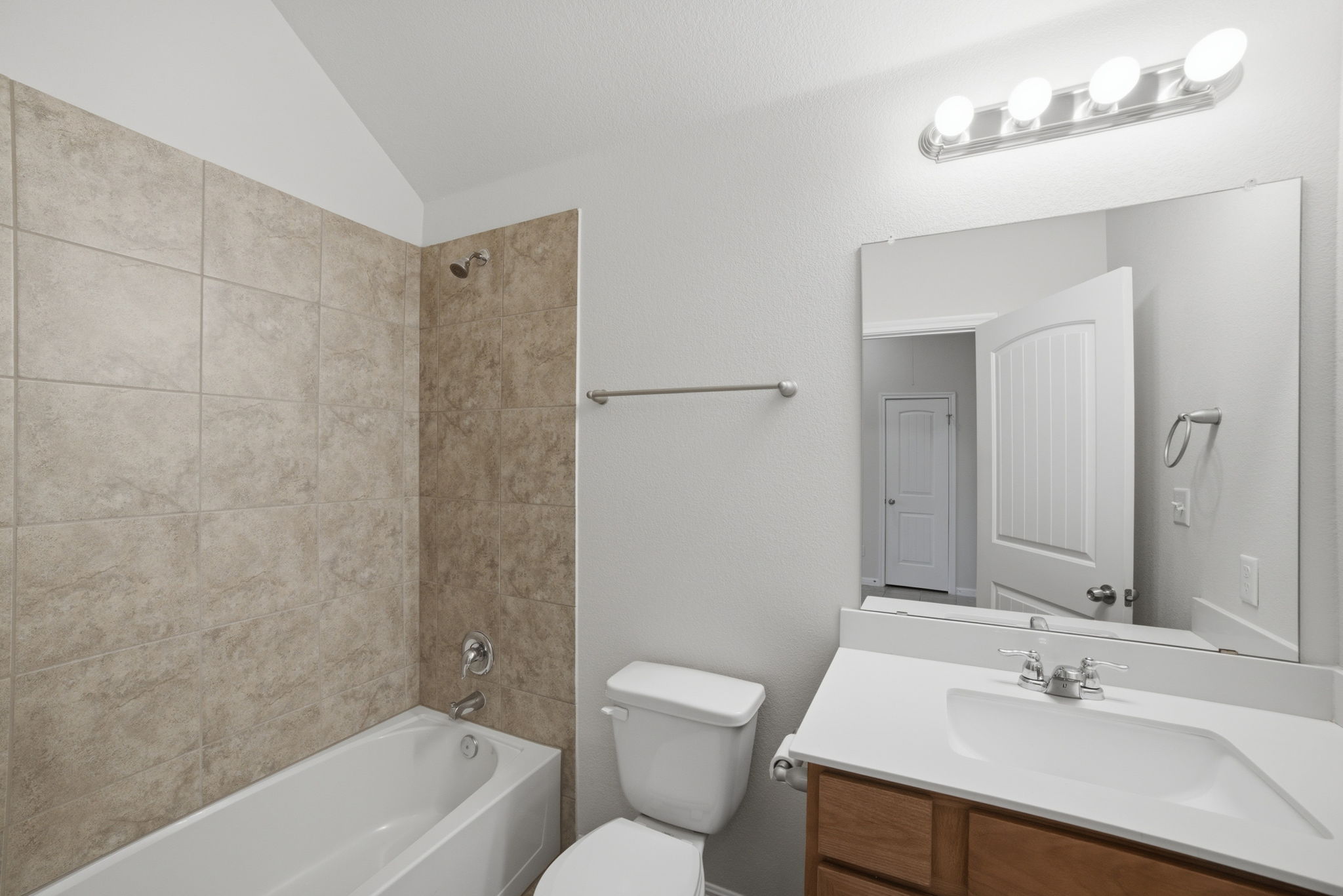 514 Nautical Loop Kyle, TX 78640 - Photo 20 of 24 A pristine bathroom featuring a classic tiled shower-tub combination and a clean vanity with ample counter space.