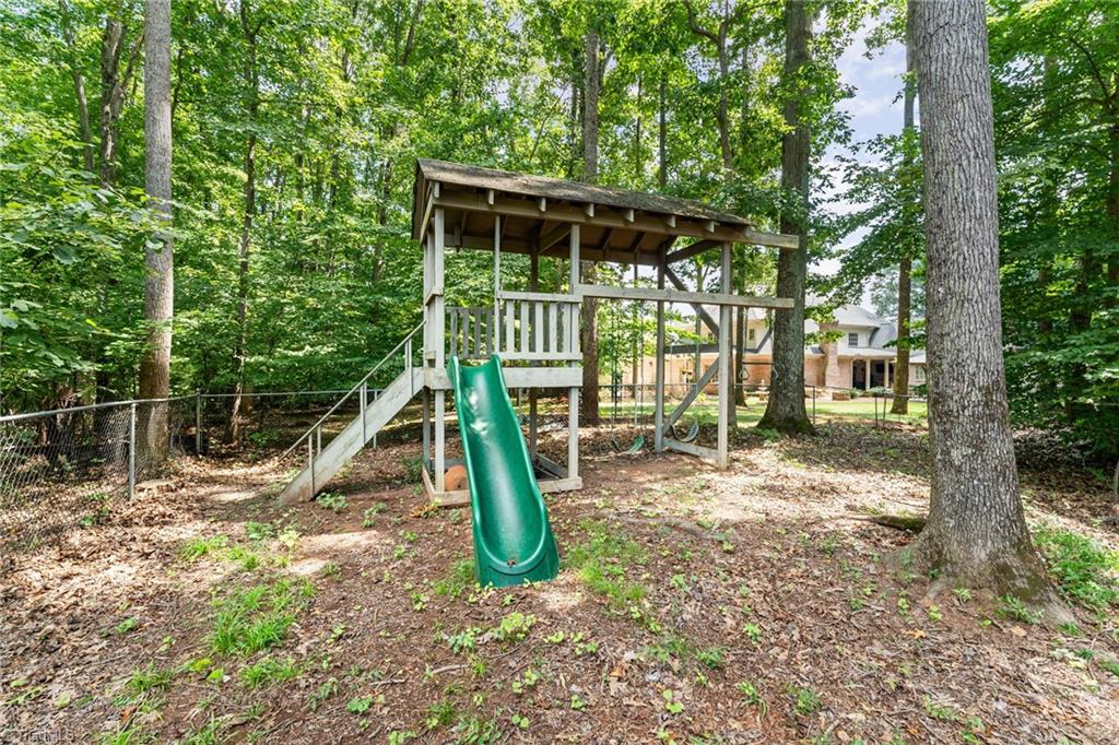 4107 Rockingham Road South Greensboro, NC 27407 - Photo 8 of 50 Large backyard with playset