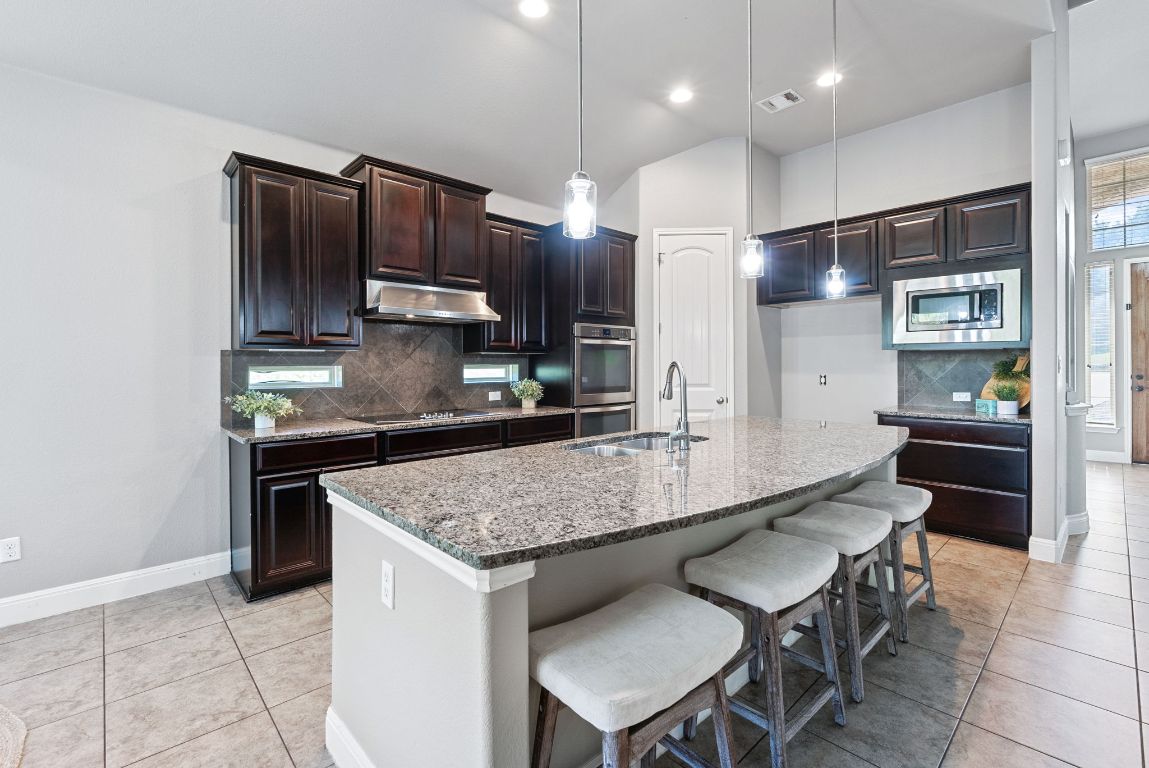 7817 Aria Loop Austin, TX 78736 - Photo 13 of 40 Spacious kitchen featuring a center island with breakfast bar.