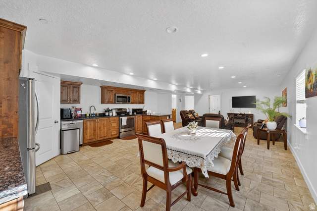141 Wolverine Creek Elk Ridge, UT 84651 - Photo 27 of 47 Dining space with light stone finish floors, a textured ceiling, and recessed lighting
