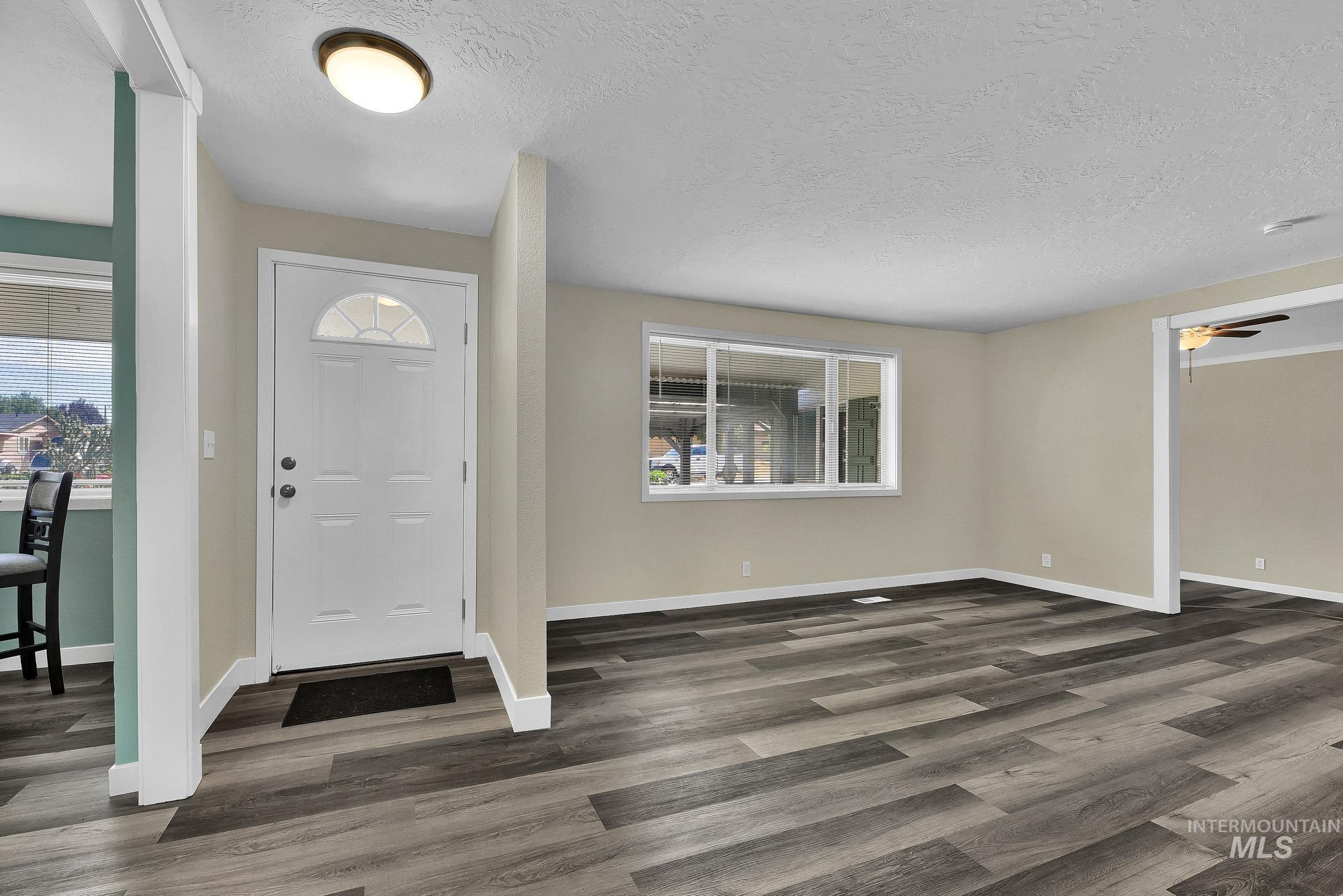 5755 Chuckwagon Road Nampa, ID 83686 - Photo 11 of 50 Entryway featuring a white paneled door with a transom window, overhead flush-mount lighting, and wood-finish flooring