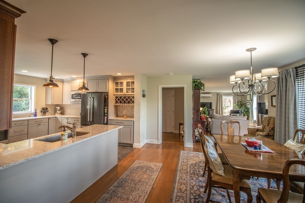 96 Cold Hill Granby, MA 01033 - Photo 18 of 42 a large dining hall with stainless steel appliances granite countertop a couch and chandelier