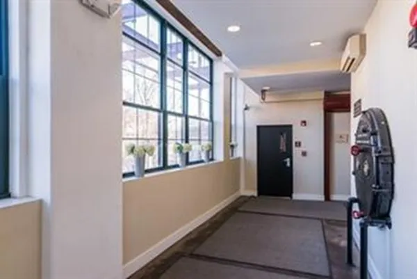 a view of a hallway with wooden floor and windows