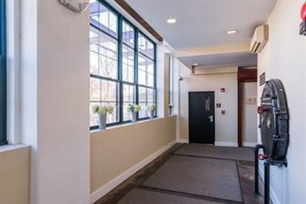 21 Illinois Street, Unit 402 Worcester, MA 01610 - Photo 3 of 16 a view of a hallway with wooden floor and windows