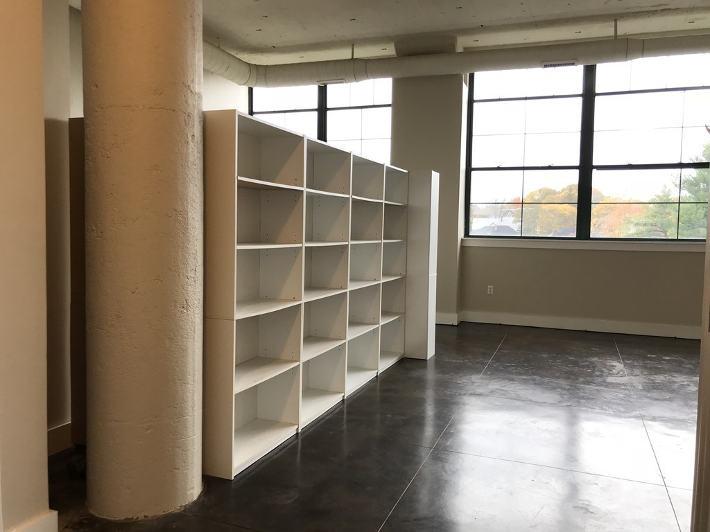21 Illinois Street, Unit 402 Worcester, MA 01610 - Photo 8 of 16 a view of a room with wooden floor and windows