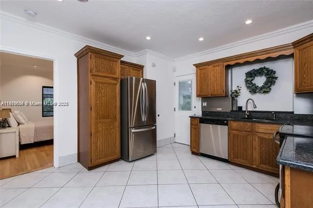 a kitchen with stainless steel appliances granite countertop a refrigerator and a stove top oven