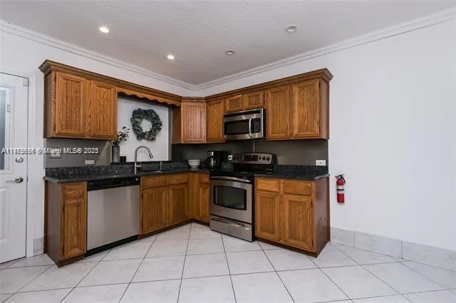 a kitchen with stainless steel appliances granite countertop a stove top oven a sink dishwasher and a microwave oven on the blue kitchen countertops