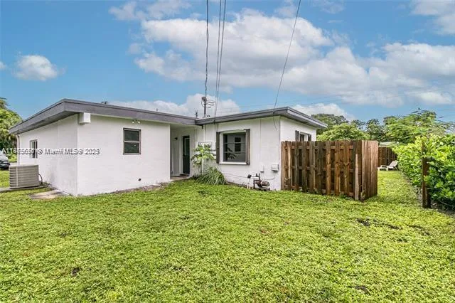 a yellow house with a flower garden in front of it