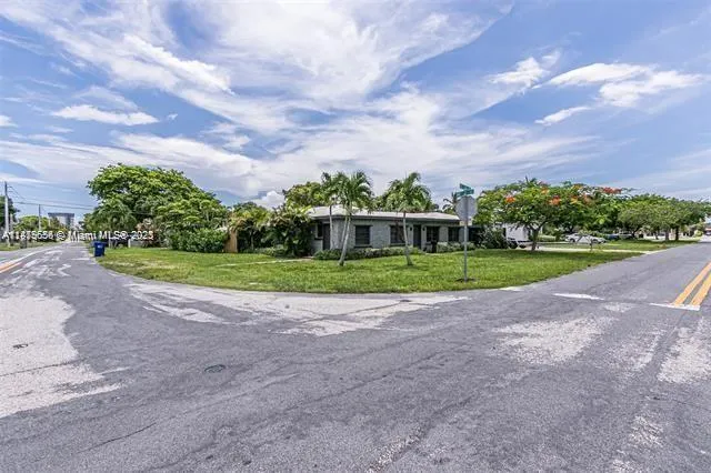 a view of a house with a big yard plants and trees