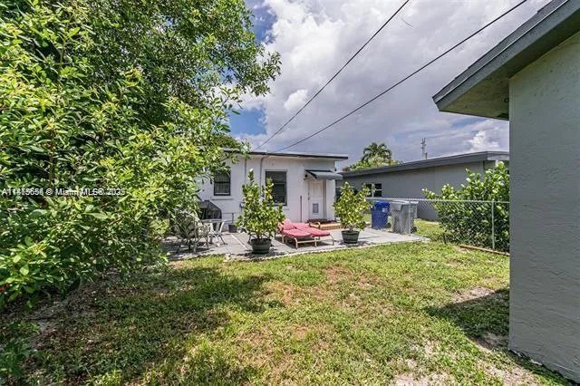 a front view of a house with a yard and potted plants
