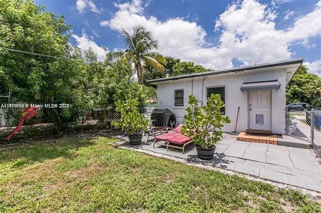 a backyard of a house with plants and large trees