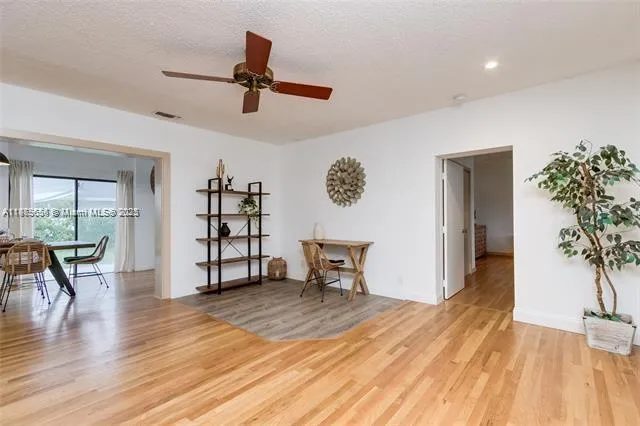a view of a livingroom with wooden floor and a ceiling fan