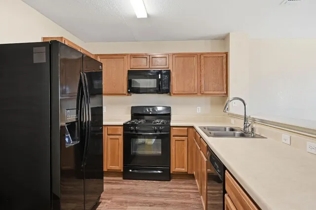 a kitchen with stainless steel appliances granite countertop a refrigerator and a stove top oven