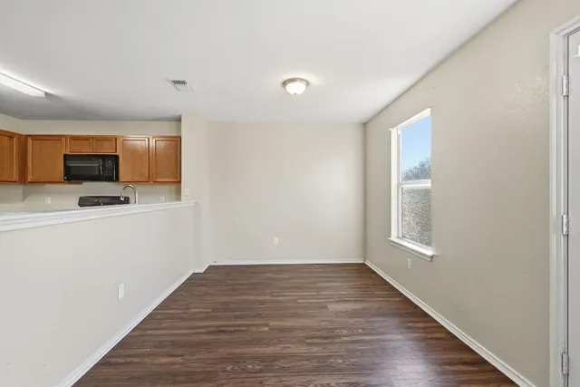 a view of a kitchen with wooden floor and electronic appliances