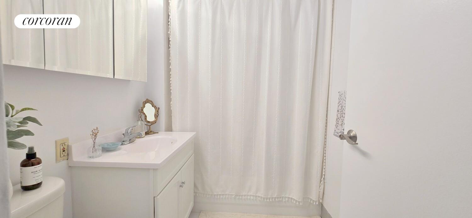 225 8th Avenue, Unit 5E Manhattan, NY 10011 - Photo 7 of 13 a bathroom with a sink and a mirror
