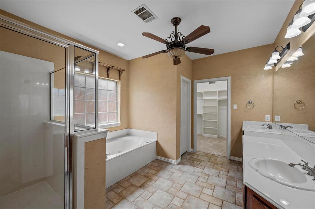 5607 Ranger Drive Rockwall, TX 75032 - Photo 22 of 40 Bathroom featuring a glass-enclosed shower, built-in soaking tub, dual vanity with white countertops, decorative ceiling fan, and tile flooring