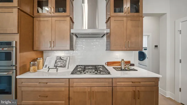 a kitchen with stainless steel appliances kitchen island granite countertop a sink and a refrigerator