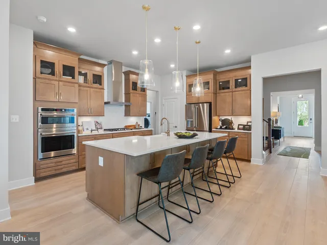 a large kitchen with kitchen island a sink a counter top space and living room view