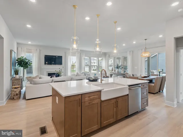 a living room with furniture a fireplace a flat screen tv and a large window