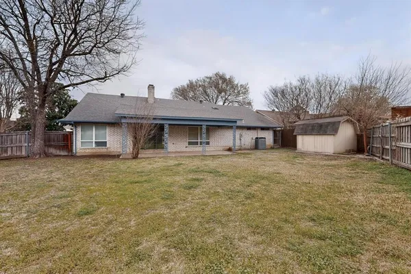 a front view of a house with a garden and tree