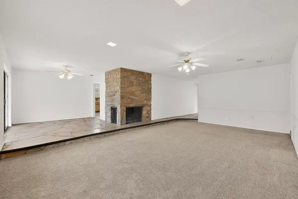 an empty room with a fireplace and fan
