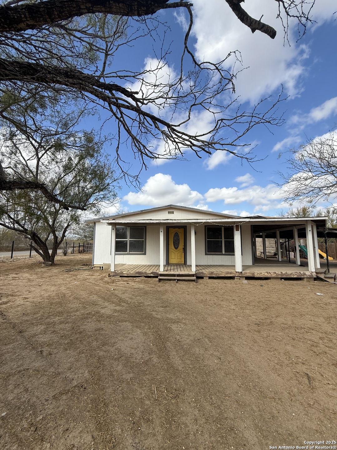 279 Cenizo Street Carrizo Springs, TX 78834 - Photo 1 of 13 a front view of a house with a yard and garage