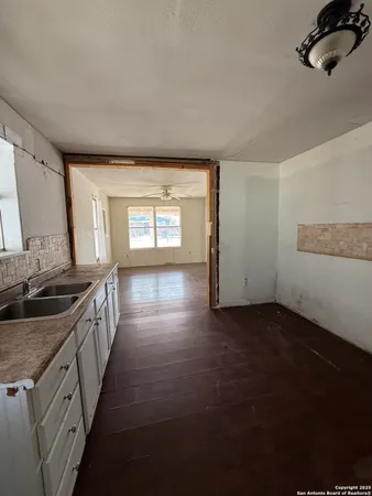a kitchen with granite countertop a sink stove and cabinets