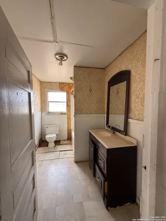 a bathroom with a sink toilet and mirror