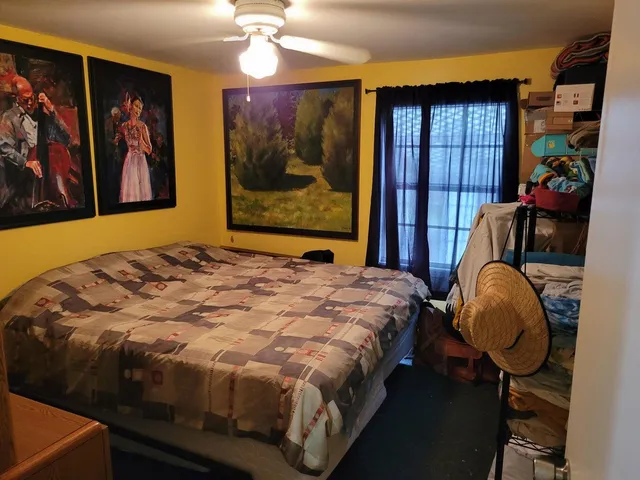 a bedroom with a bed and painting on the wall