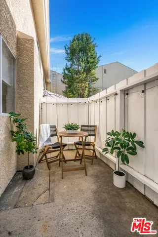 a view of a chairs and table in the backyard
