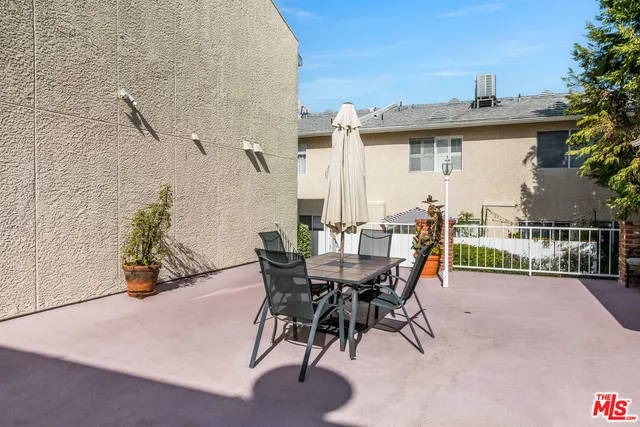 a view of a patio with table and chairs and potted plants