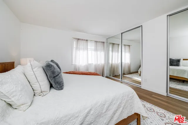 a spacious bedroom with a bed and a refrigerator