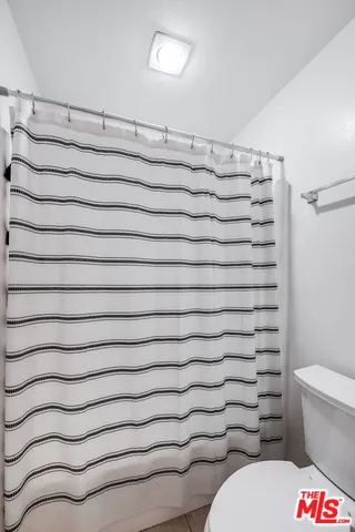 a bathroom with a toilet and a shower curtain
