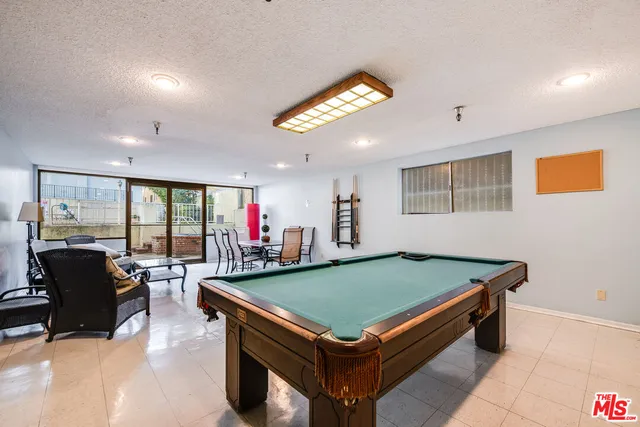 a room with pool table and glass windows