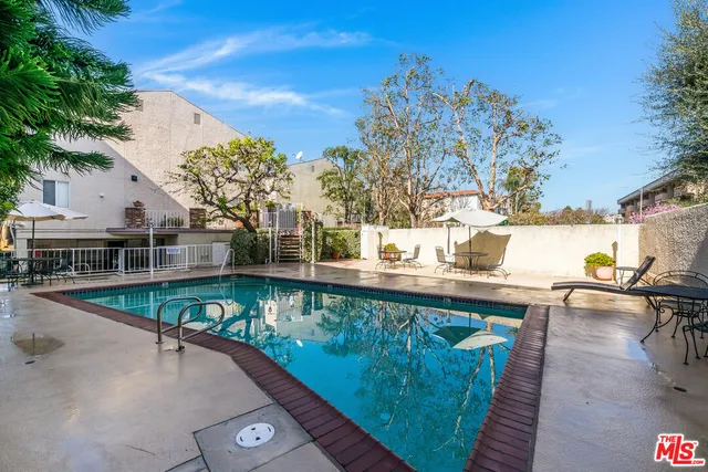 a view of a swimming pool with a patio and a yard
