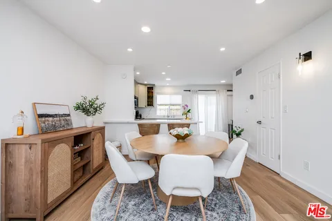 a view of a dining room with furniture a rug and wooden floor