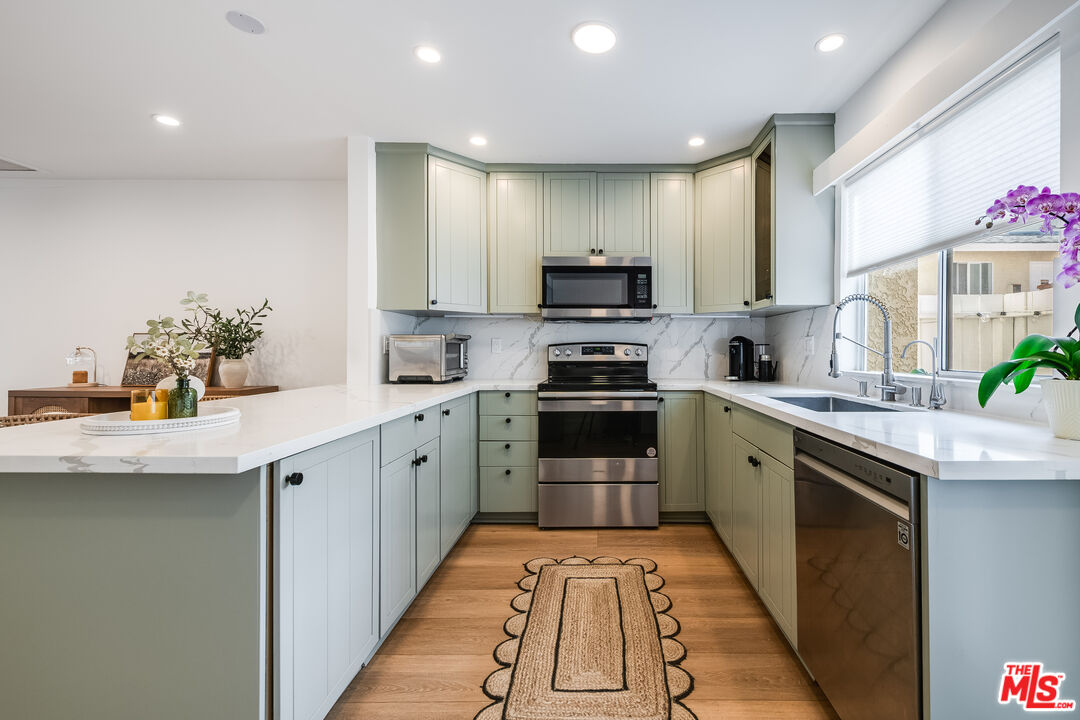 4558 Willis Avenue, Unit 121 Sherman Oaks, CA 91403 - Photo 10 of 34 a kitchen with stainless steel appliances a sink dishwasher stove refrigerator and cabinets