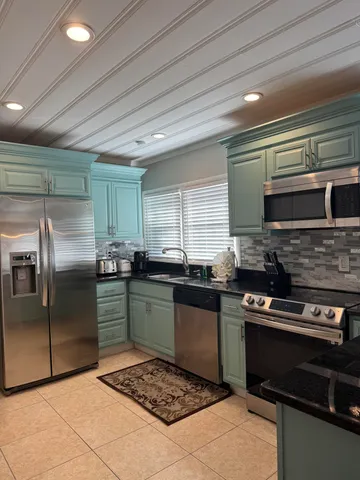 a kitchen with stainless steel appliances kitchen island granite countertop a stove sink and cabinets