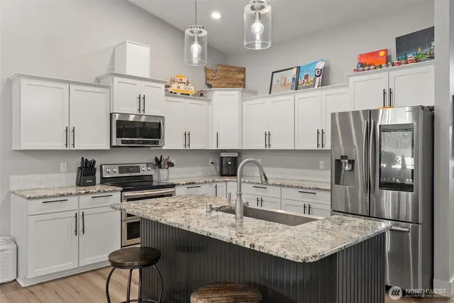 a kitchen with stainless steel appliances granite countertop a sink stove and refrigerator