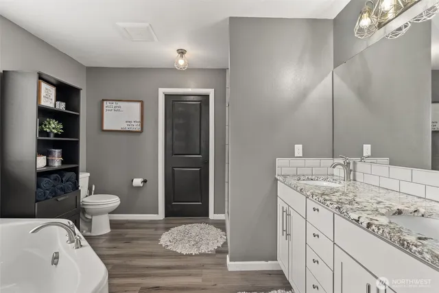 a bathroom with a granite countertop sink toilet and shower