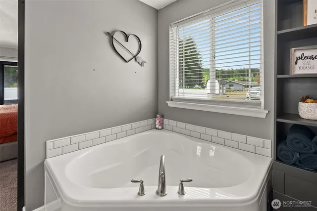 a white bath tub sitting in a bathroom next to a window